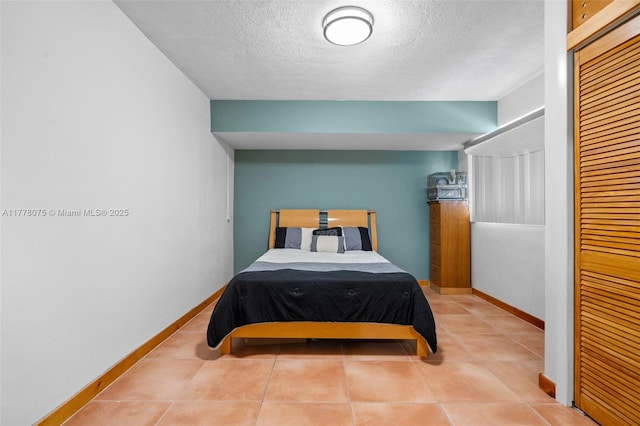 2447 SE 15th St, Pompano Beach, FL 33062 - tiled bedroom featuring a closet, a textured ceiling, and baseboards