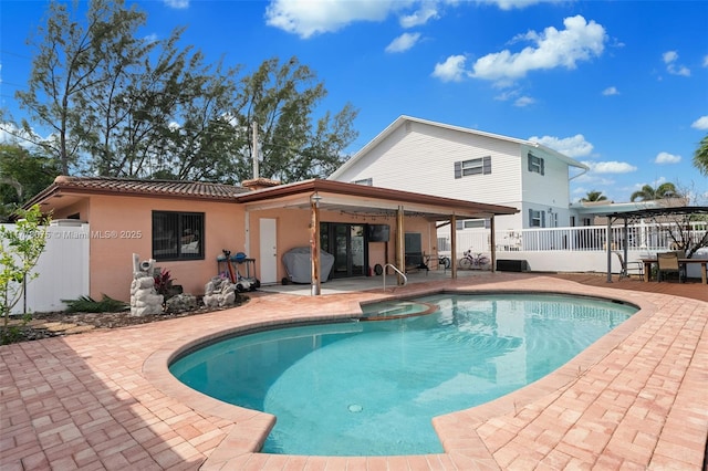 2447 SE 15th St, Pompano Beach, FL 33062 - back of property with a patio area, a pool with connected hot tub, and fence