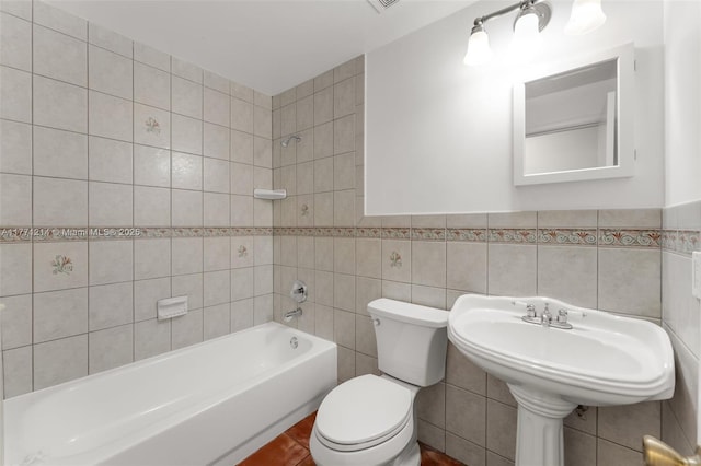 bathroom with toilet, tile walls, and shower / tub combination