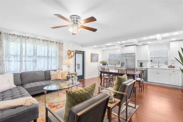 living area with beam ceiling, a ceiling fan, a wealth of natural light, and recessed lighting