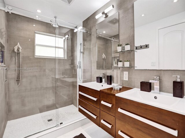 1273 NE 92nd St, Miami Shores, FL 33138 - full bath with a shower stall, double vanity, tile walls, and recessed lighting