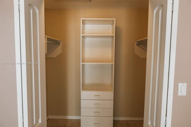 walk in closet with light tile patterned floors