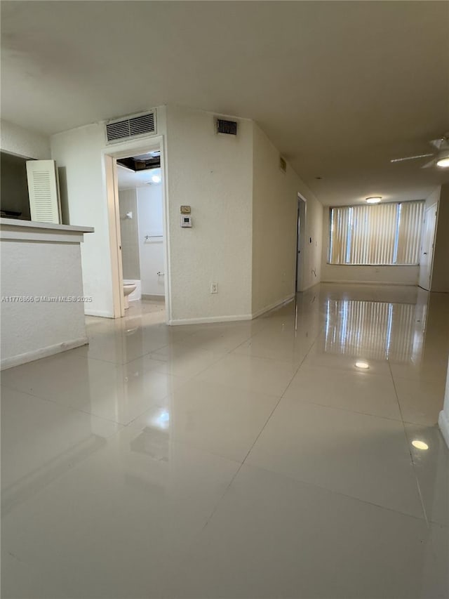 unfurnished room featuring baseboards, tile patterned flooring, and visible vents