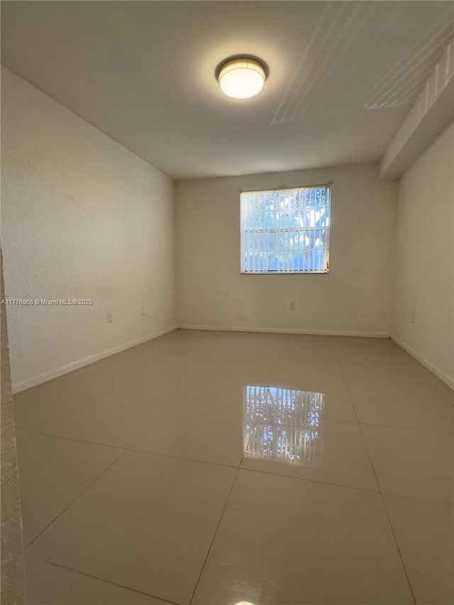 unfurnished room featuring tile patterned floors and baseboards