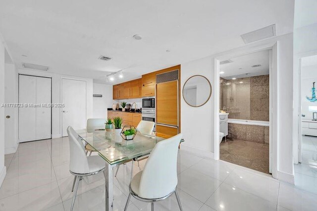 485 SE Brickell Ave Unit 1711, Miami, FL 33131 - dining room featuring baseboards, light tile patterned floors, and attic access