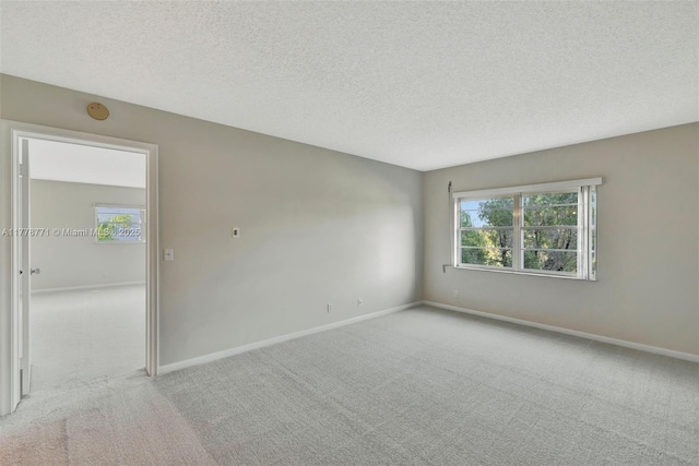 12701 SW 13th St Unit 301F, Pembroke Pines, FL 33027 - empty room featuring light carpet, baseboards, and a textured ceiling