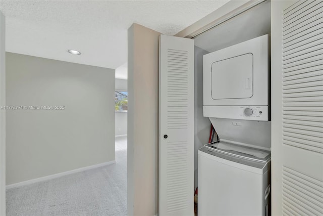 12701 SW 13th St Unit 301F, Pembroke Pines, FL 33027 - clothes washing area featuring baseboards, a textured ceiling, carpet floors, stacked washer / dryer, and laundry area