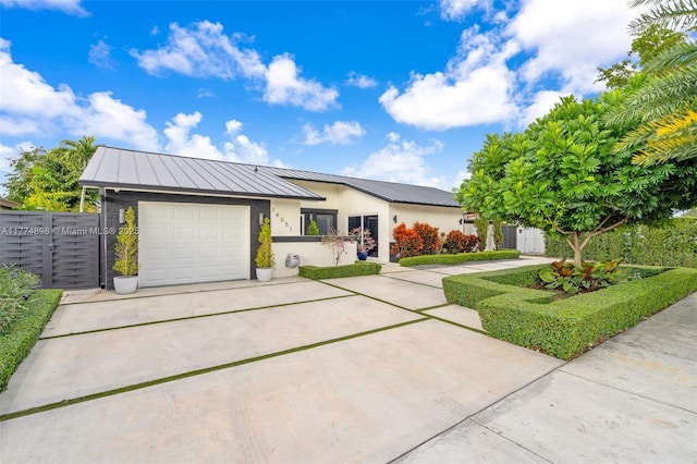 view of front facade with an attached garage, fence, driveway, and stucco siding