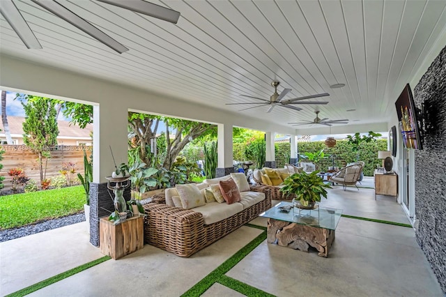 sunroom with an outdoor living space, finished concrete floors, and a ceiling fan