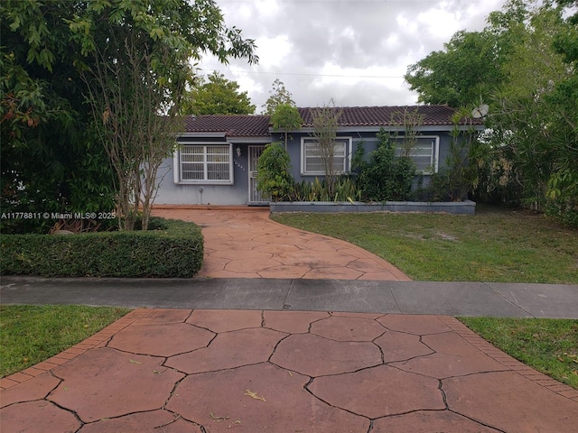 10041 SW 14th Ter, Miami, FL 33174 - view of front of home with a tiled roof, stucco siding, a front yard, and driveway