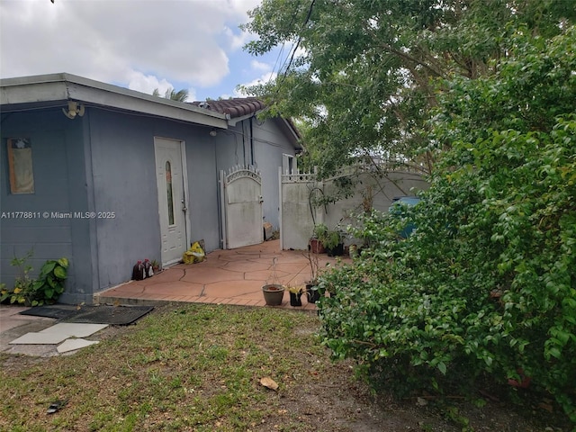 10041 SW 14th Ter, Miami, FL 33174 - view of property exterior with a patio area, stucco siding, and a tile roof