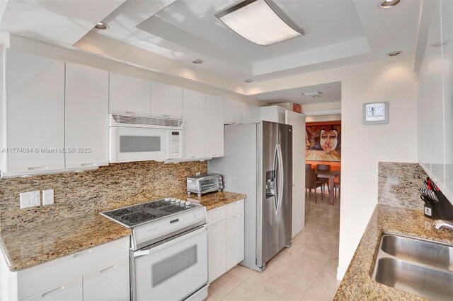 2000 Island Blvd Unit 503, Aventura, FL 33160 - kitchen featuring white appliances, a raised ceiling, backsplash, light stone countertops, and recessed lighting