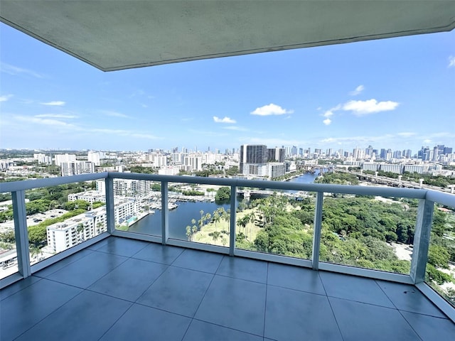 balcony with a water view and a view of city