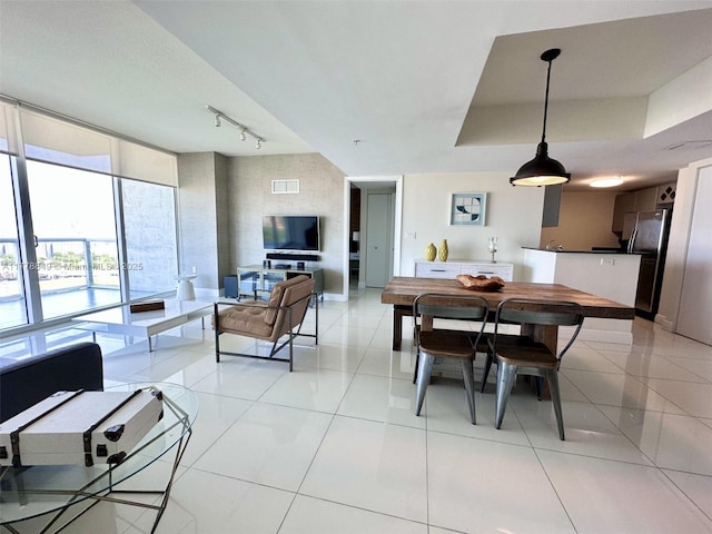 dining space with light tile patterned flooring, floor to ceiling windows, rail lighting, and visible vents