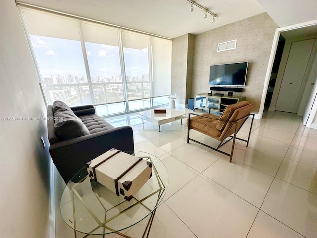 living area featuring visible vents, tile patterned floors, track lighting, and floor to ceiling windows