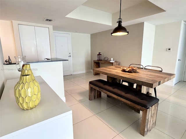 dining space featuring light tile patterned floors, visible vents, and baseboards