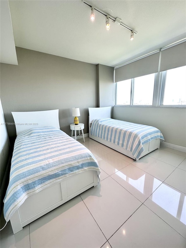 bedroom featuring tile patterned flooring and baseboards