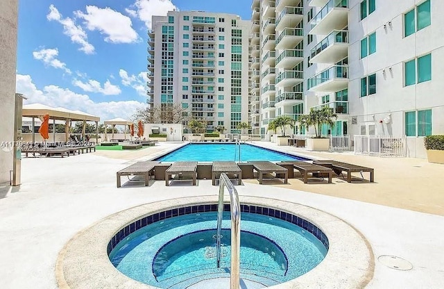 pool with a community hot tub and a patio