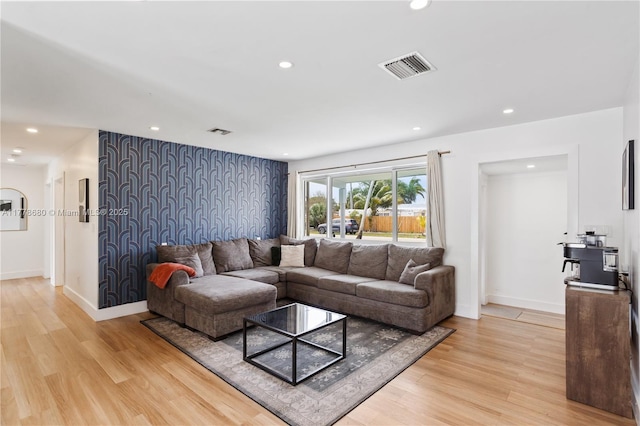 living area featuring baseboards, visible vents, light wood-style floors, and recessed lighting
