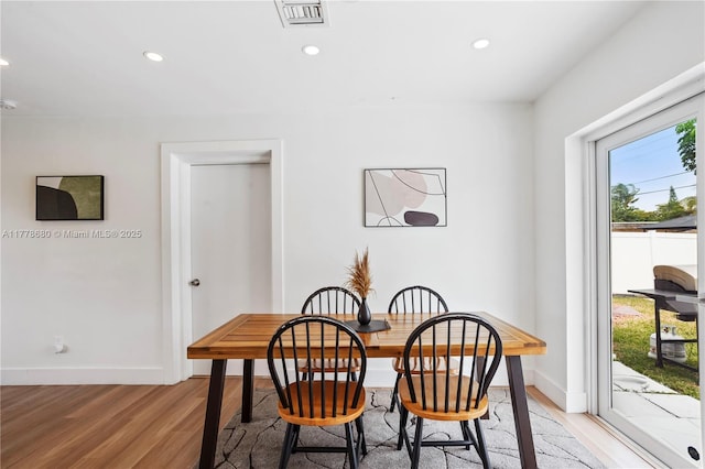 dining area with light wood finished floors, recessed lighting, visible vents, and baseboards