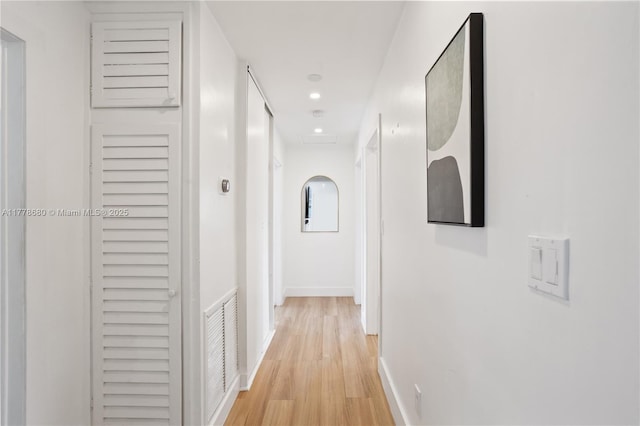 corridor featuring light wood-style floors, recessed lighting, visible vents, and baseboards