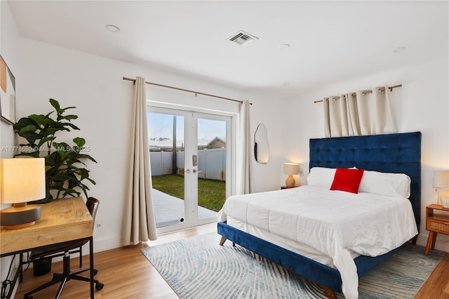 bedroom featuring visible vents, french doors, access to exterior, and light wood-style floors