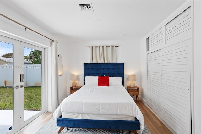 bedroom featuring access to exterior, visible vents, and light wood-style floors