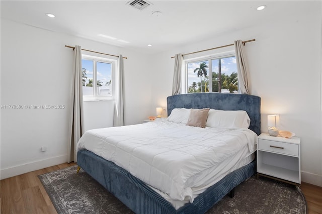 bedroom featuring wood finished floors, visible vents, recessed lighting, and baseboards
