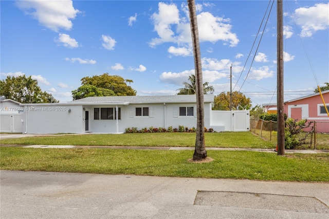 ranch-style home with a front yard, stucco siding, fence private yard, and a gate