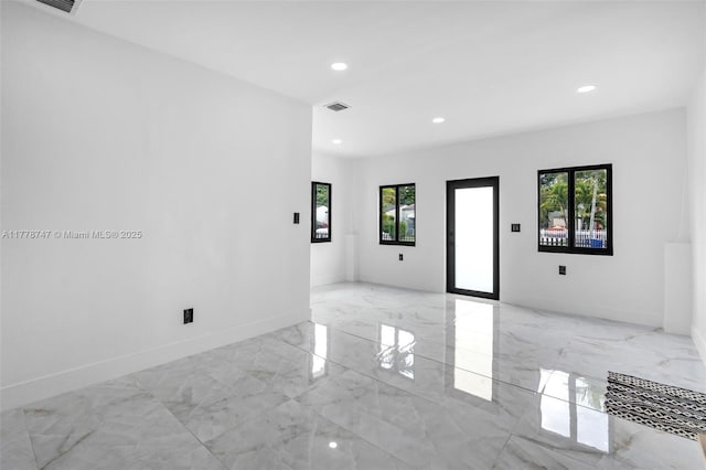 spare room with marble finish floor, baseboards, visible vents, and recessed lighting