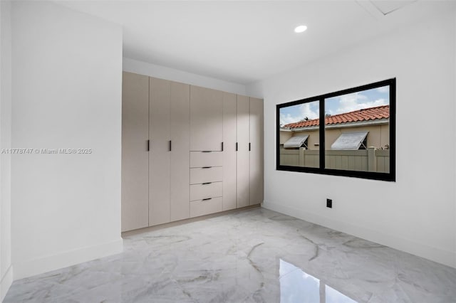 unfurnished bedroom with recessed lighting, marble finish floor, and baseboards