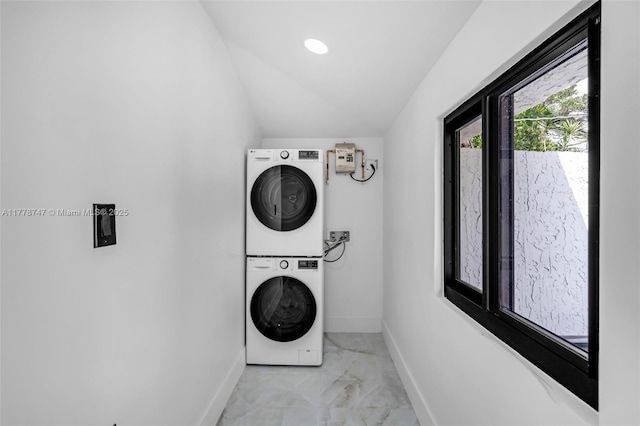 laundry room with laundry area, stacked washer / drying machine, and baseboards