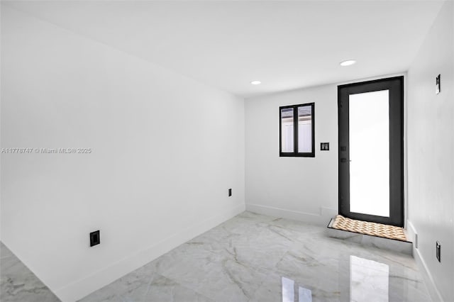 empty room featuring recessed lighting, marble finish floor, and baseboards