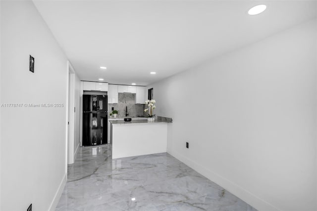 kitchen with baseboards, white cabinetry, freestanding refrigerator, decorative backsplash, and marble finish floor