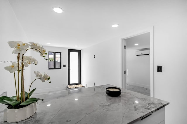 interior space featuring a wall unit AC and recessed lighting