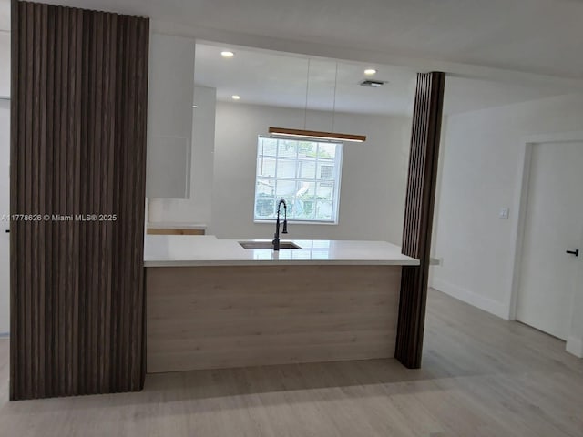 3242 NW 87th Ter, Miami, FL 33147 - kitchen featuring light wood-type flooring, recessed lighting, light countertops, visible vents, and a sink