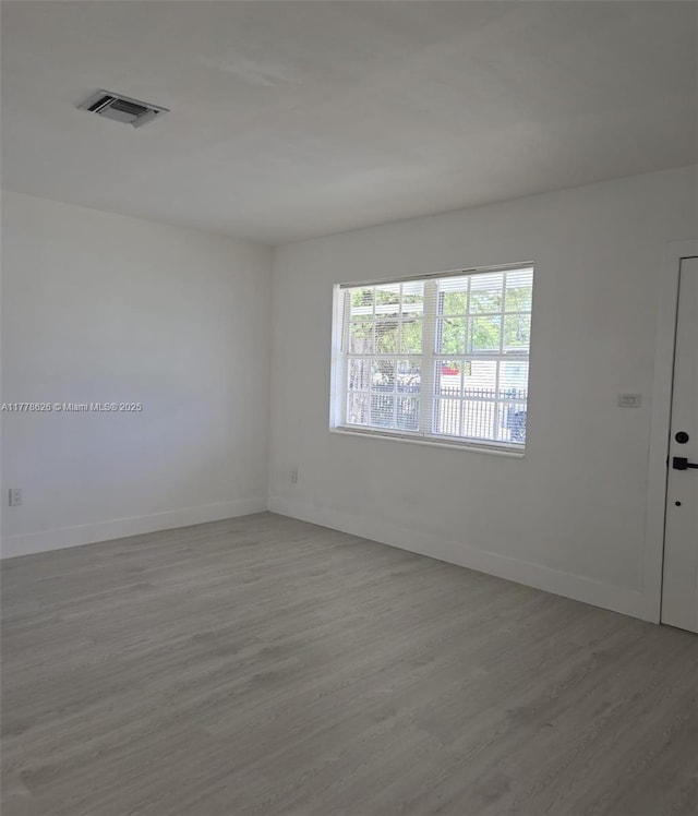3242 NW 87th Ter, Miami, FL 33147 - empty room with visible vents, baseboards, and wood finished floors