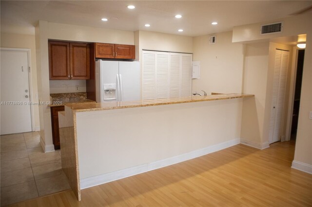 unfurnished bedroom with light wood-style flooring, a textured ceiling, a closet, and baseboards