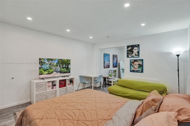 bedroom with recessed lighting, wood finished floors, and baseboards