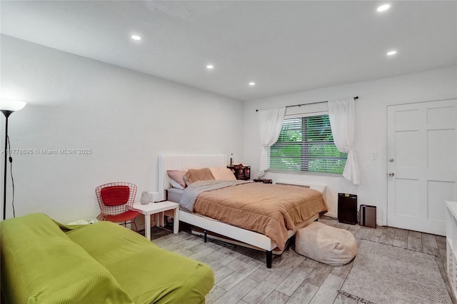bedroom with light wood finished floors and recessed lighting
