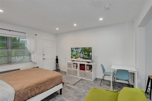 bedroom with recessed lighting, wood finished floors, and baseboards