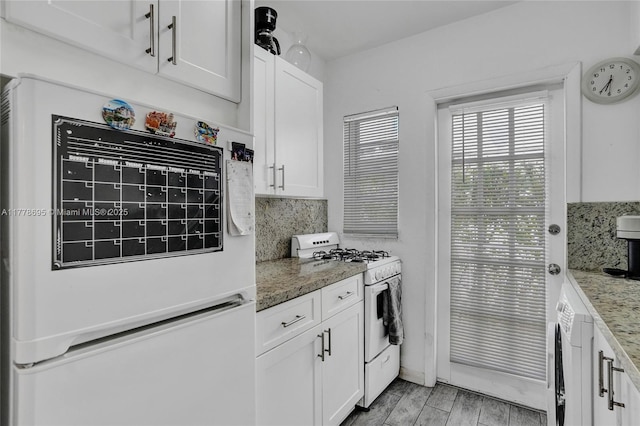 kitchen with gas range gas stove, tasteful backsplash, white cabinetry, washer / clothes dryer, and light stone counters