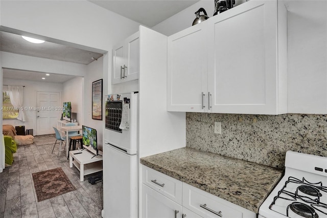 kitchen featuring white cabinets, decorative backsplash, light stone countertops, and white appliances