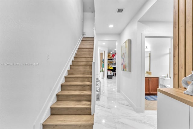 stairway featuring visible vents, baseboards, recessed lighting, and marble finish floor