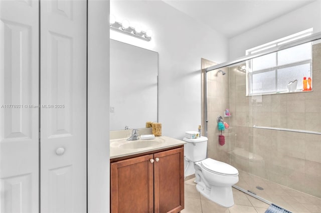full bath with vanity, a closet, a stall shower, tile patterned flooring, and toilet