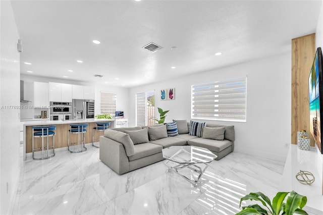 living room featuring visible vents, baseboards, and recessed lighting