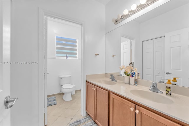 full bathroom with a sink, tile patterned floors, toilet, and double vanity