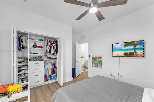bedroom with wood finished floors, ceiling fan, a closet, and visible vents