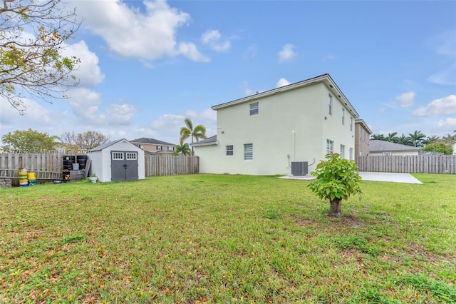 rear view of house with a fenced backyard, an outdoor structure, a patio, a storage unit, and stucco siding