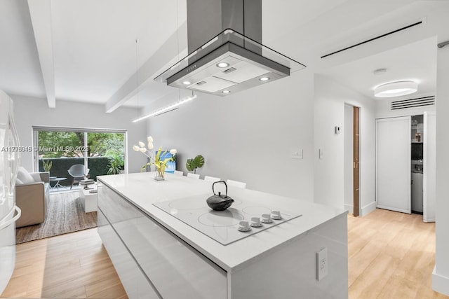 kitchen featuring a center island, white electric stovetop, light wood-style floors, beam ceiling, and island exhaust hood